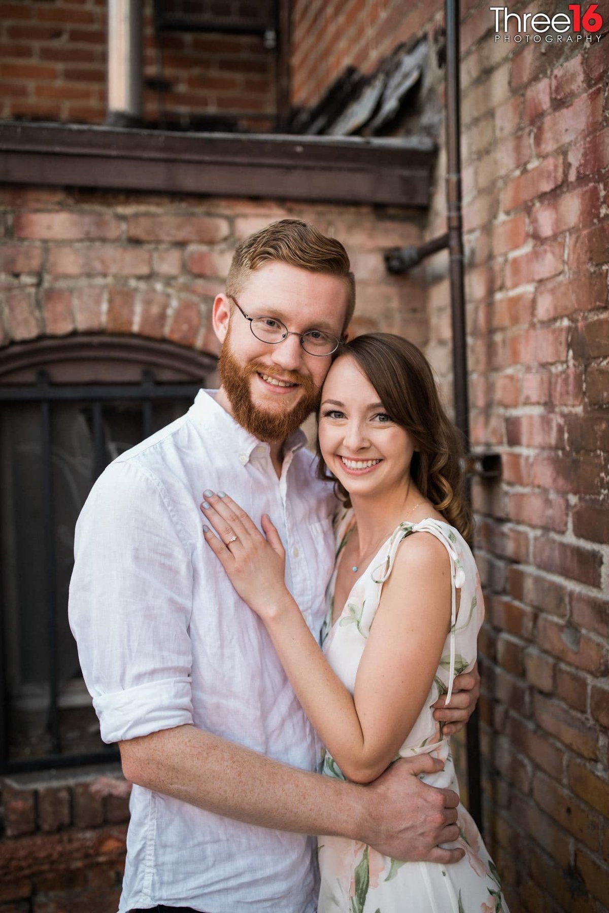 Engaged couple embrace one another in an Old Towne Orange alley