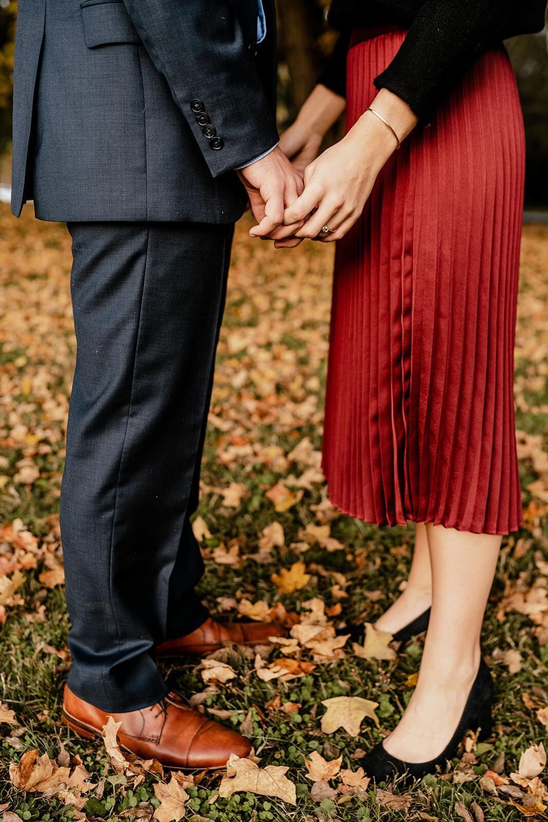 close up shot of hands in front of the autumn leaves at percy warner park during engagement session in nashville