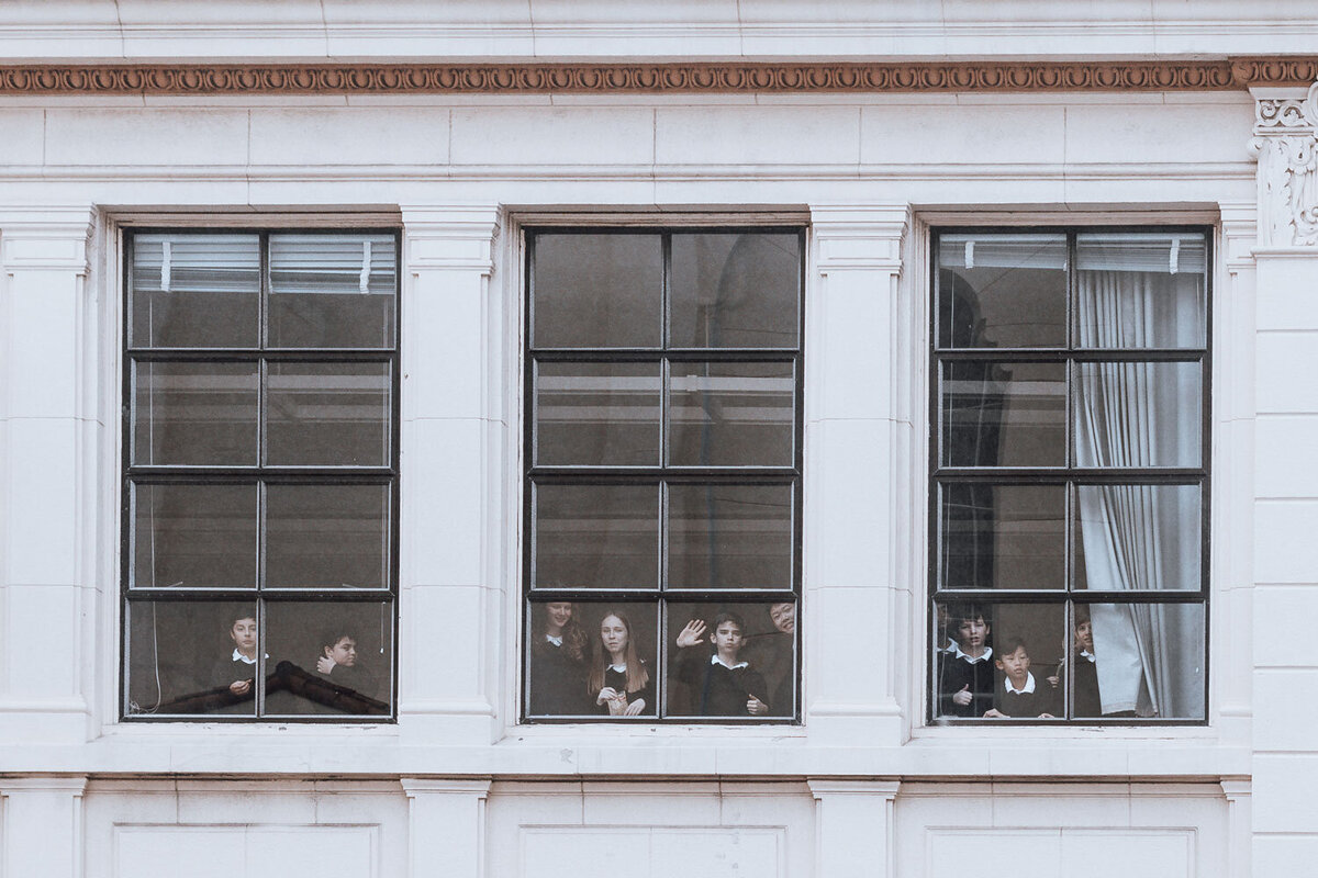 kids waving out of school window