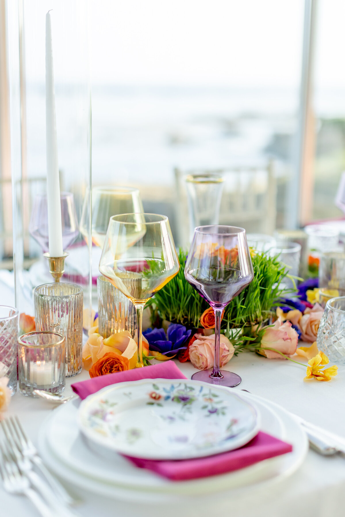 Patterned Plate with pink napkins and colored glassware