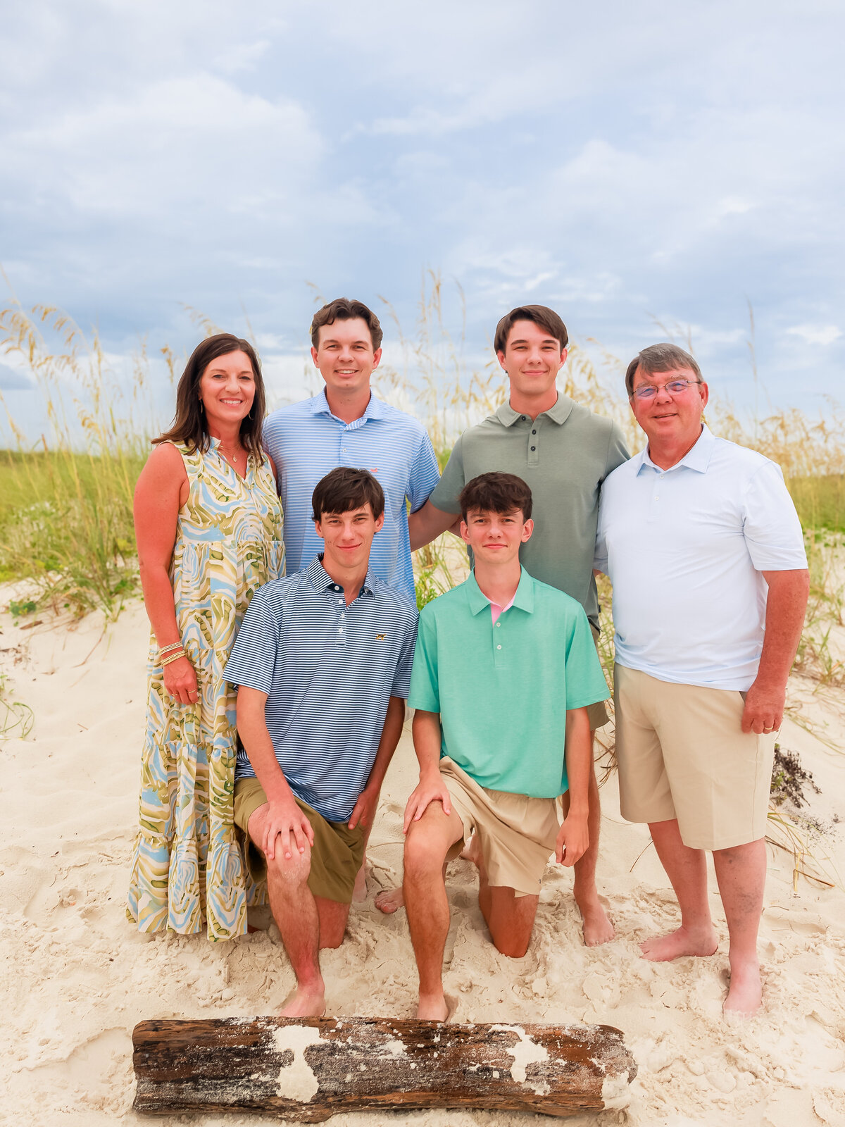 family standing in front of sand dune with 4 teenage boys