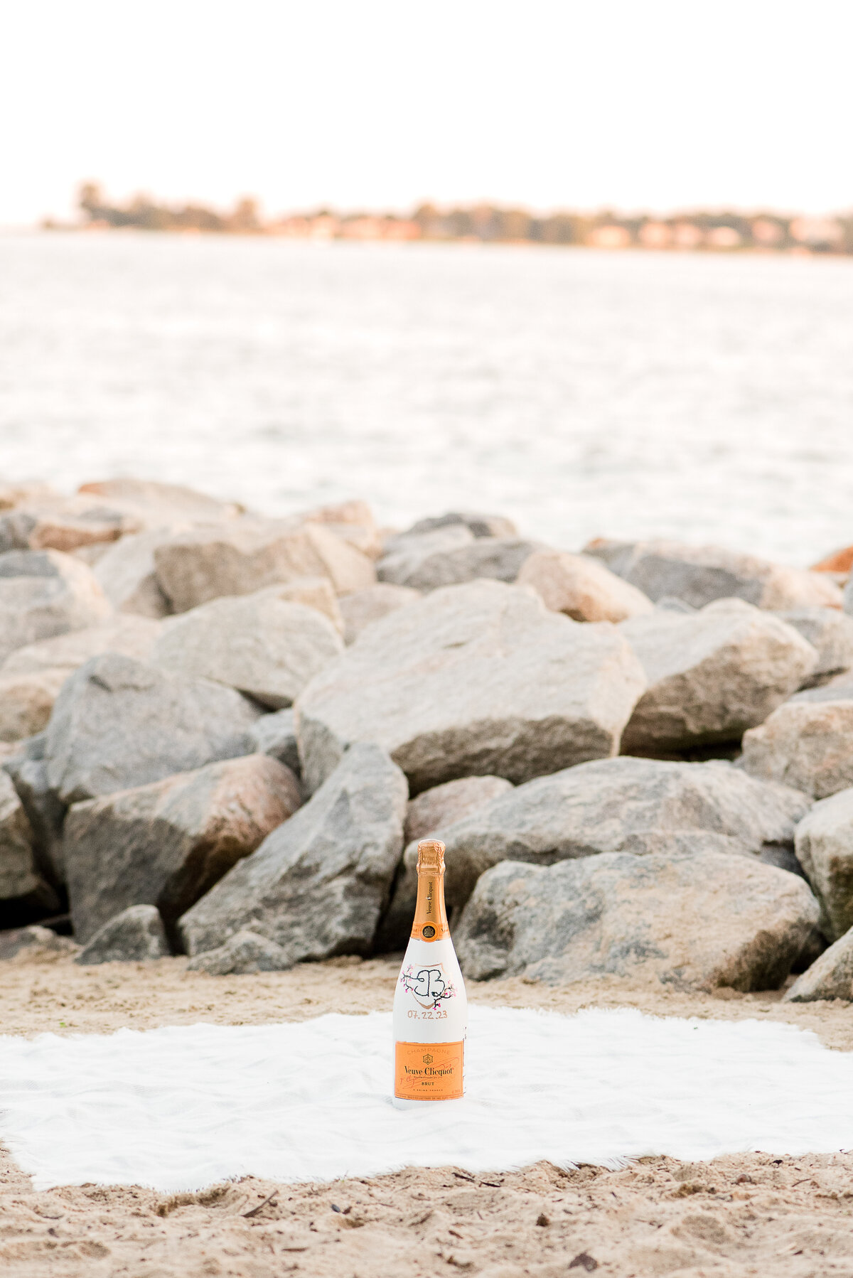 custom champagne bottle on picnic blanket at the beach