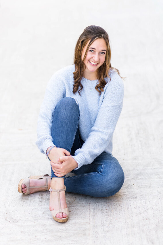 Senior girl sitting on white tiles