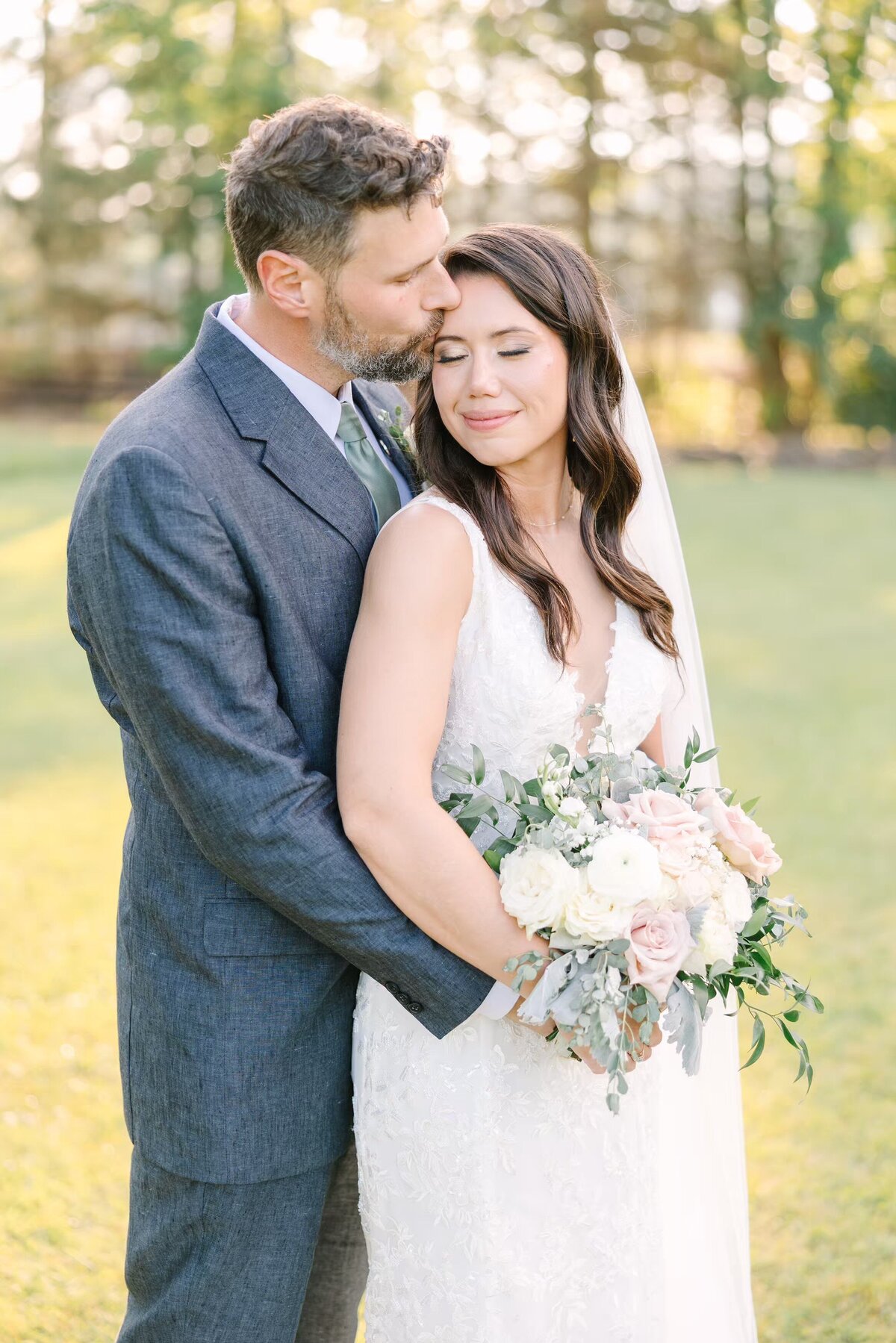 Groom romantically kisses bride on temple