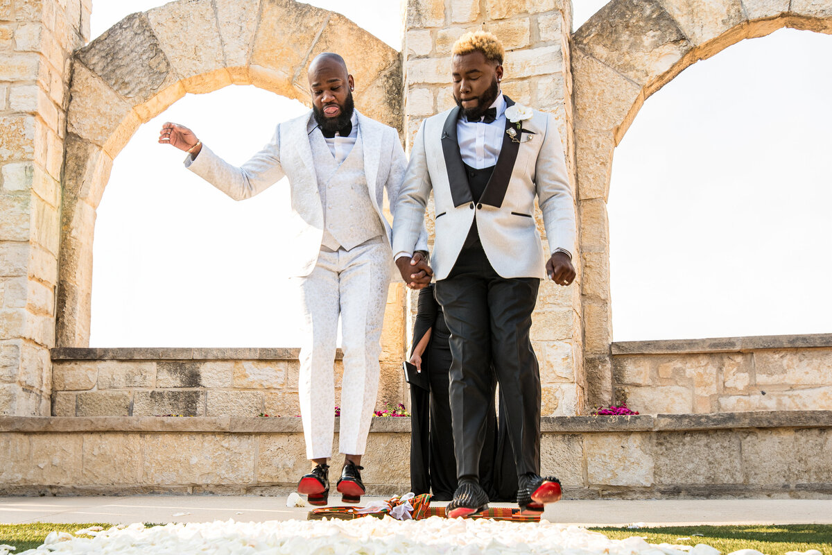 Black gay grooms in Austin jumping the broom to celebrate their marriage.