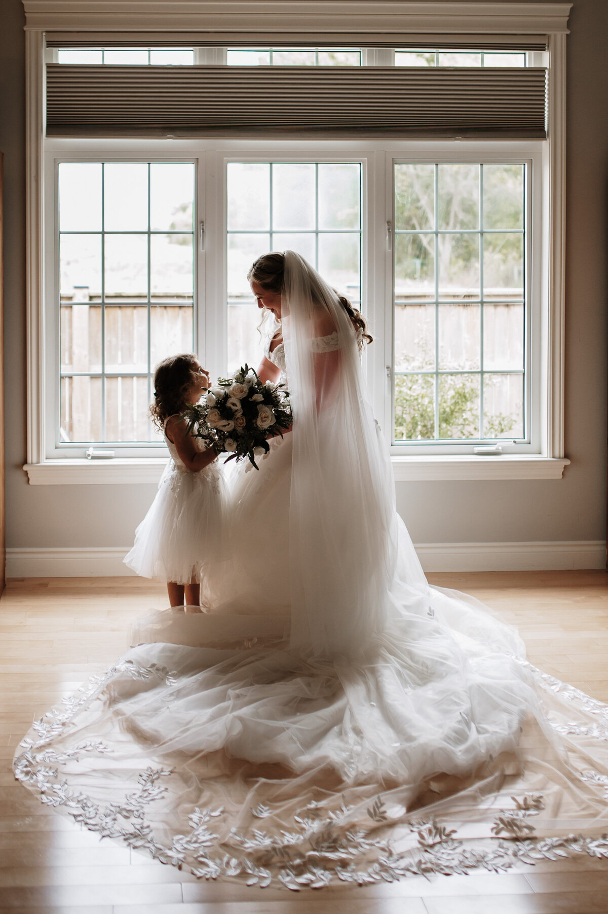 candid moment between bride and flower girl
