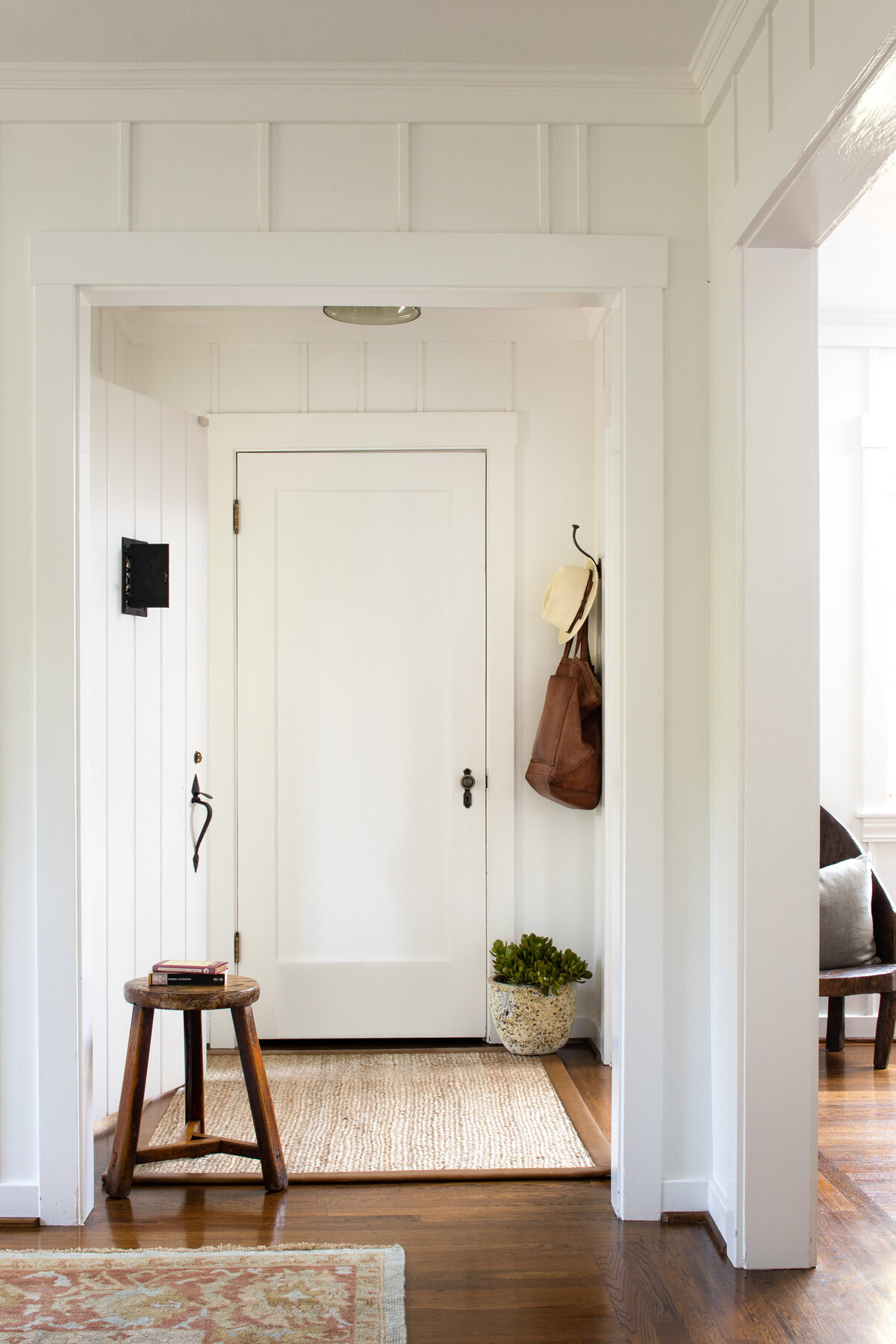 Bright entryway with white decor and natural elements, captured in interior photography