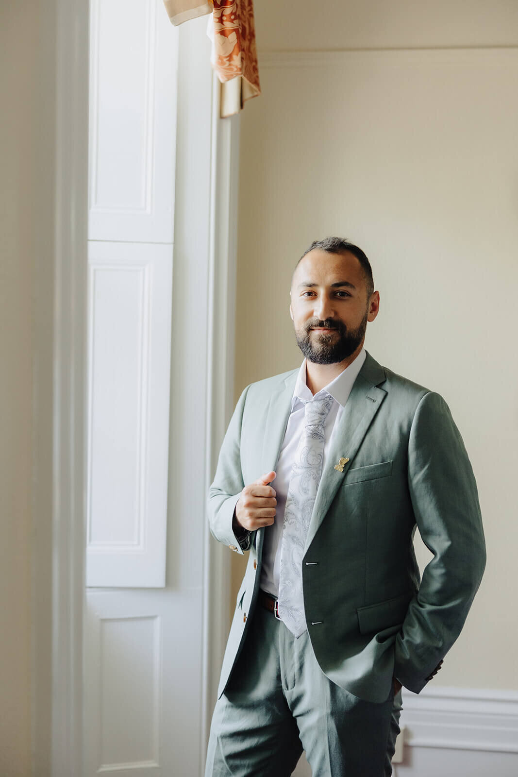 Groom wearing gray suit for wedding at the Mansion at Keuka Lake, NY