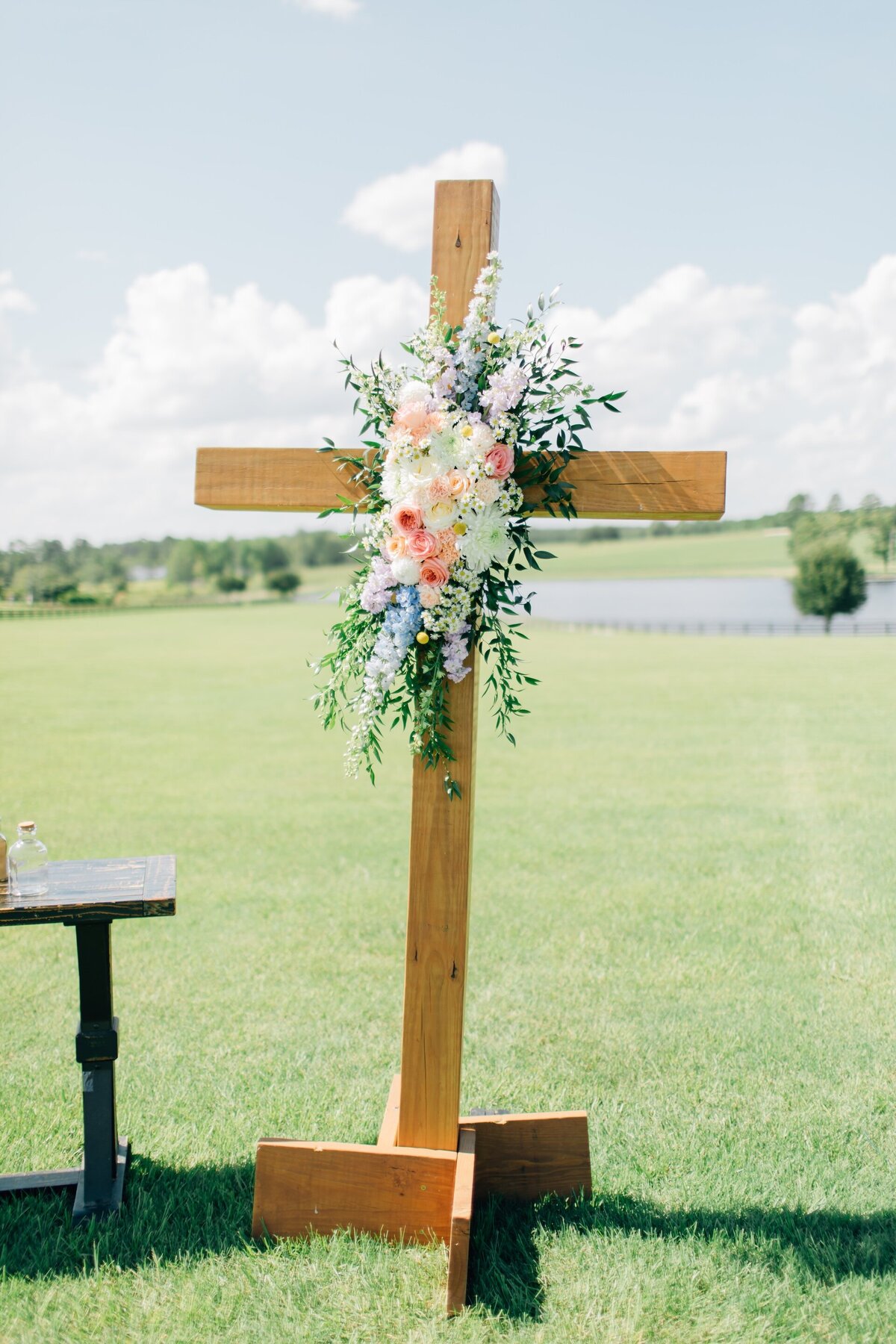 a wooden cross decorated with a flower arrangement