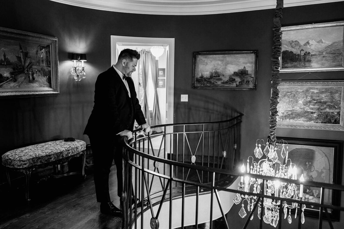 groom looking down the staircase at the Manor at Greencrest Manor