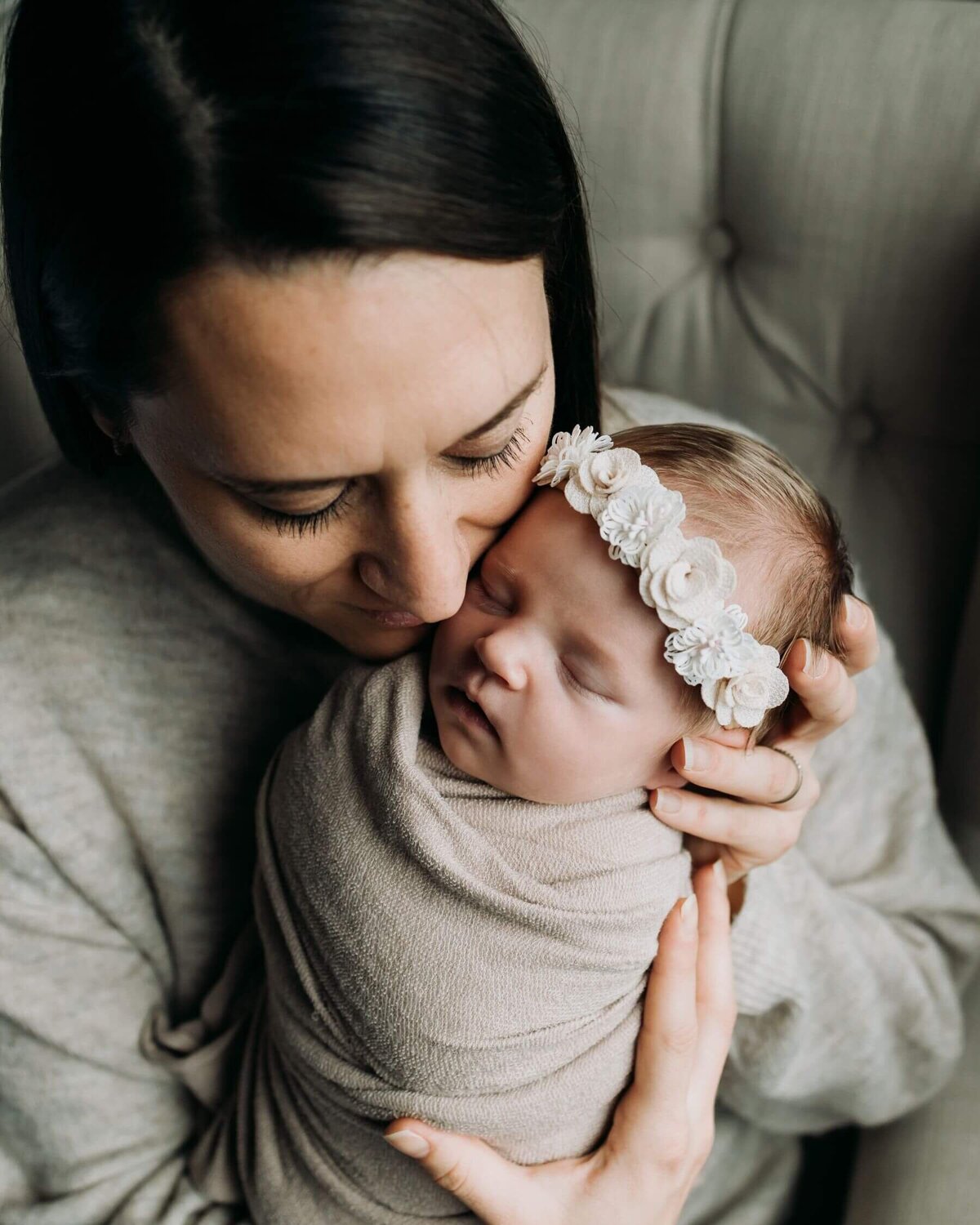 A new mother cradles her baby girl close