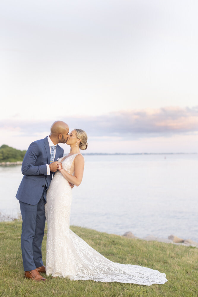 bride and groom kiss by the lake - gold shoes and wedding details - branford house wedding