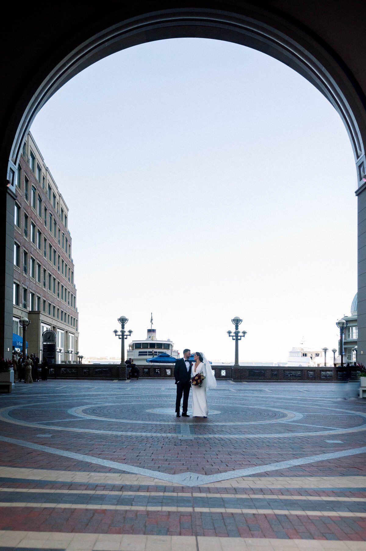 bride and groom standing in a plaza at the Boston Harbor Hotel
