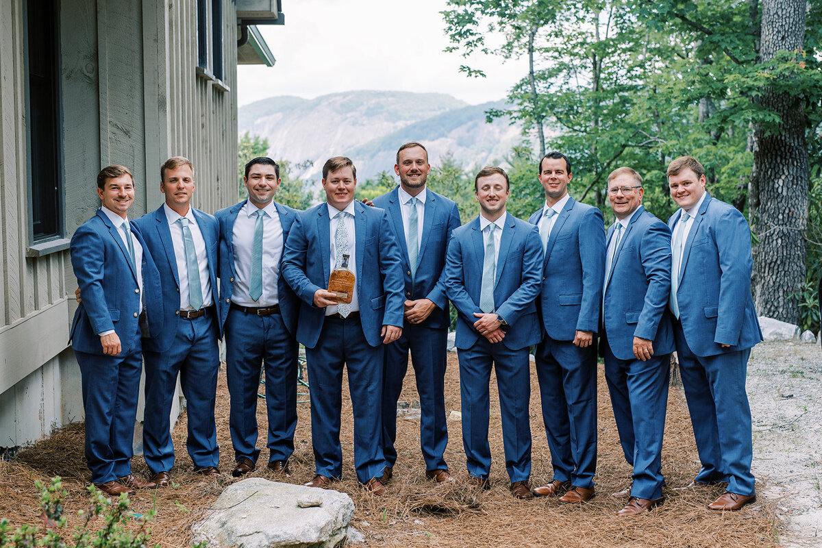 A group shot of a groom and his groomsmen after digging up a bourbon bottle. 