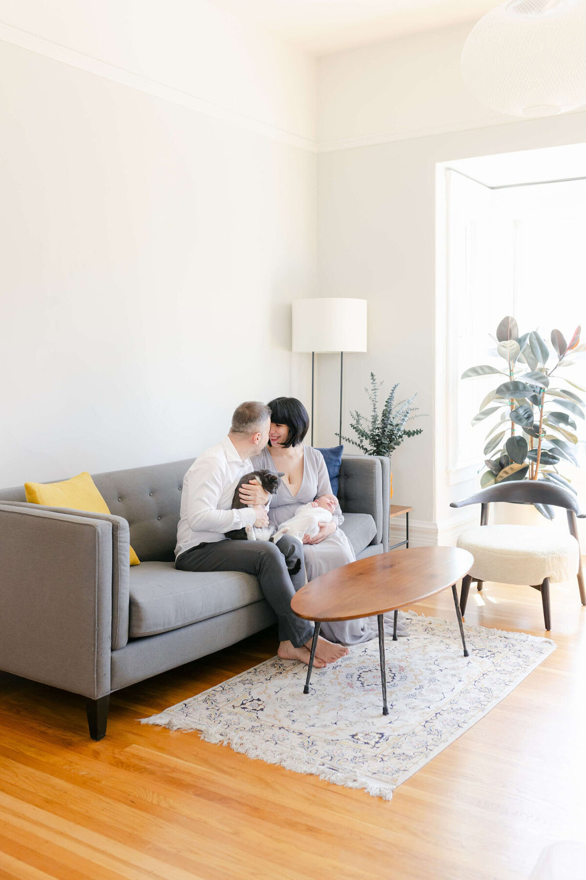 Cozy living room Bay Area newborn photography session with baby wrapped in a blanket.