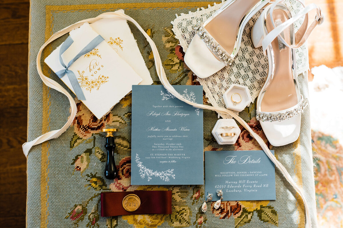 Chatlottesville wedding detail shot with wedding invitation, brides heels and other details laying on the corner of a vintage rug