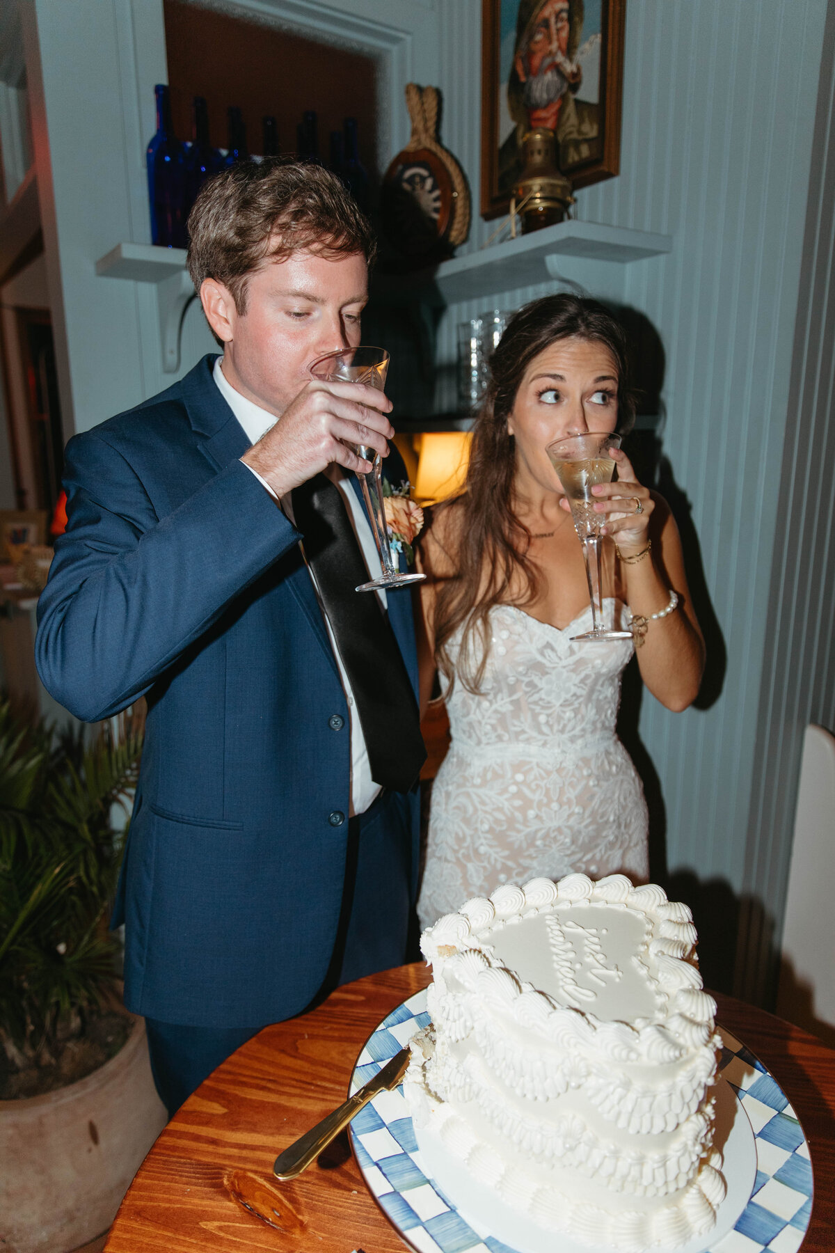 Bride and Groom drinking from champagne flutes after cutting heart shaped vintage cake