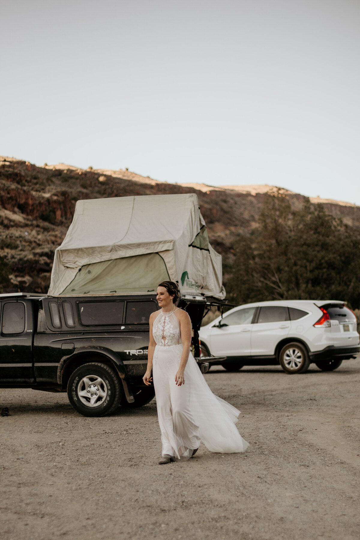 bride walking away from truck with tent on top
