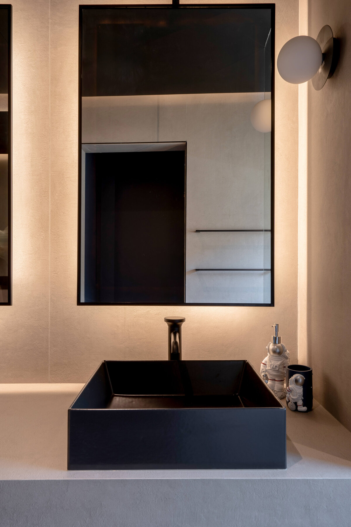 Sleek modern black sink on grey counter in en suite bathroom.