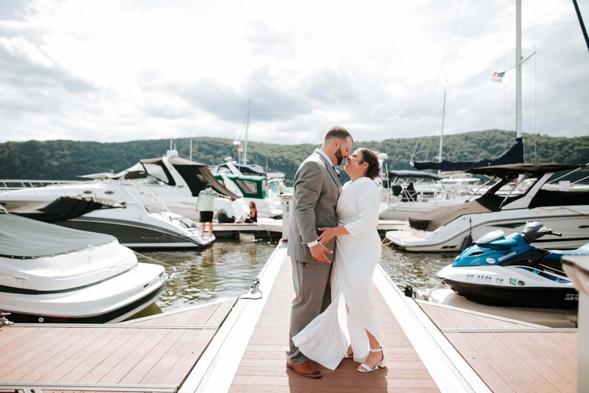 Bride and Broom sharing a special moment on the marina in Hudson Valley surrounded by boats and water.