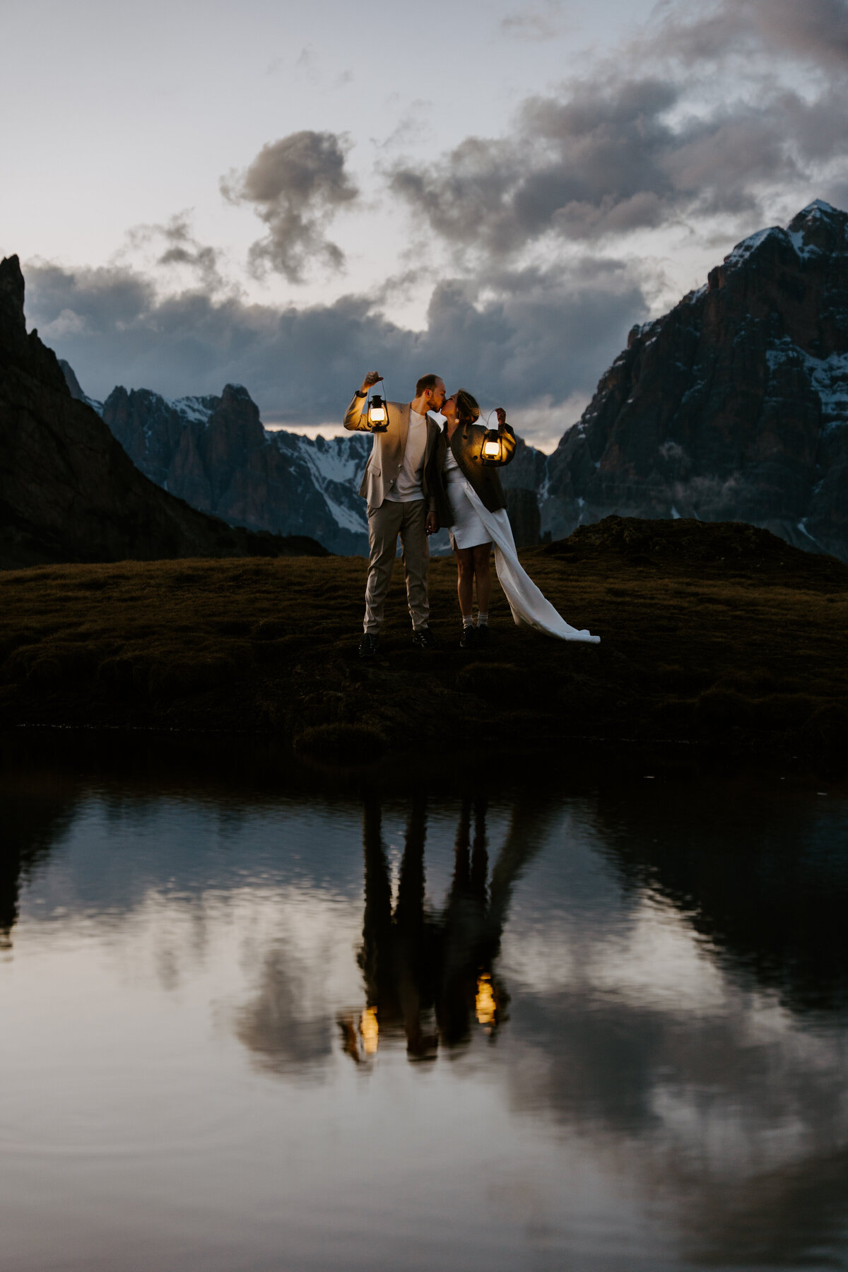 Romantic reflection of couple in mountain lake after sunset