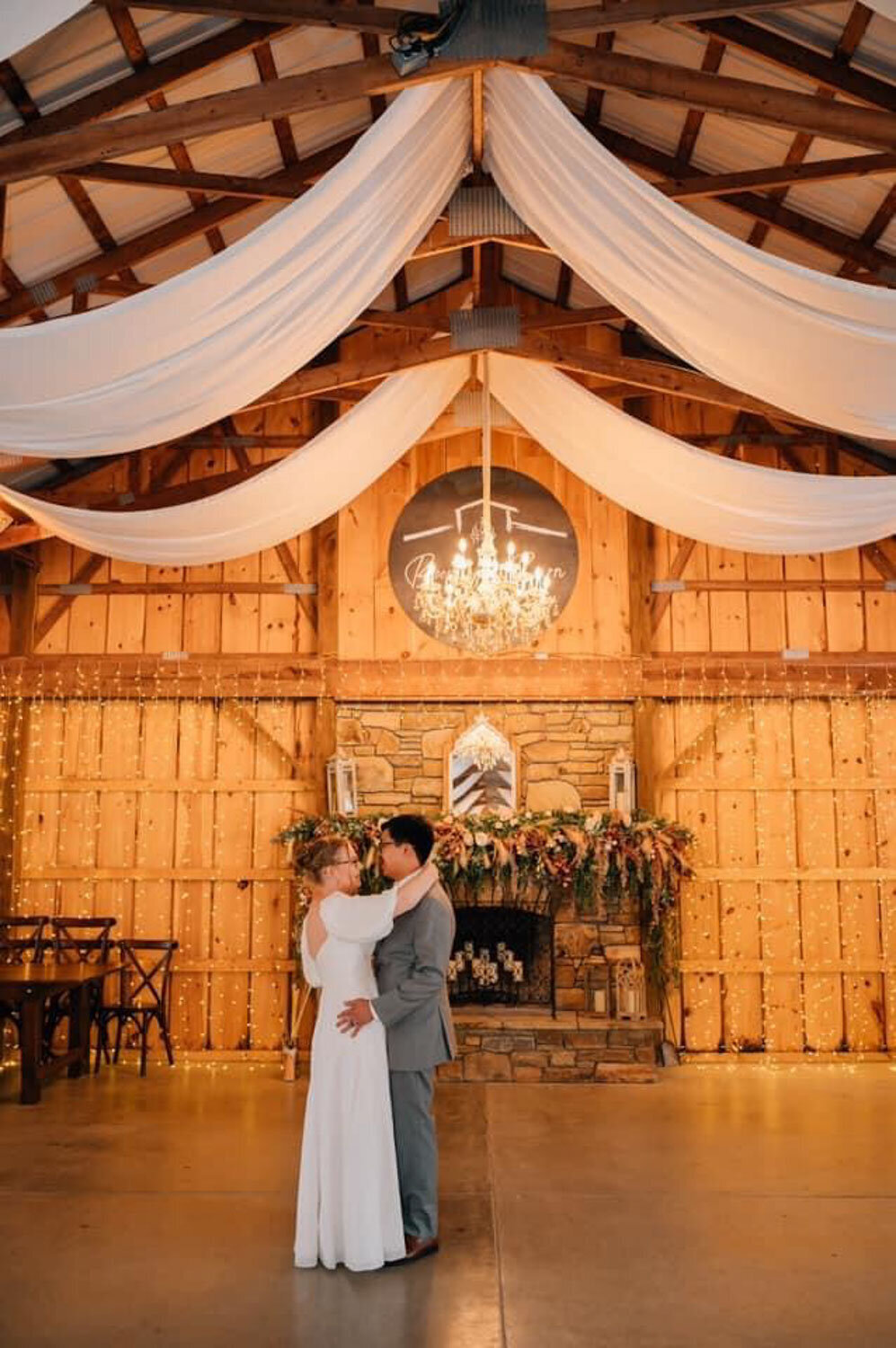 Bride and groom’s first dance in a rustic, decorated hall