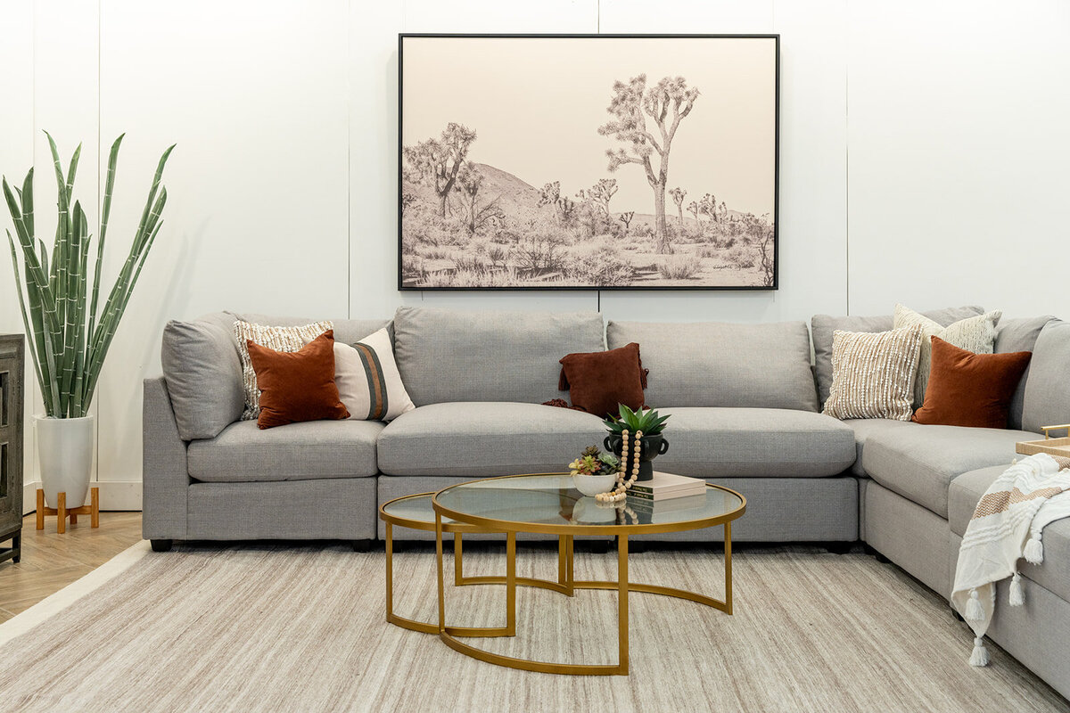 Grey couch with red accents and accent art