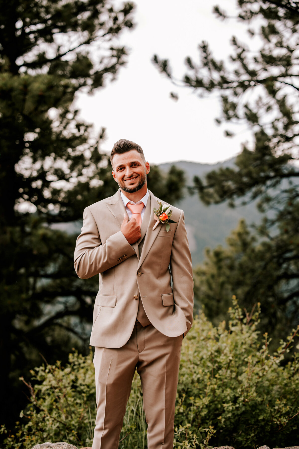 Husband in a tan suit holding his collar waiting for his bride in Boulder, Colorado
