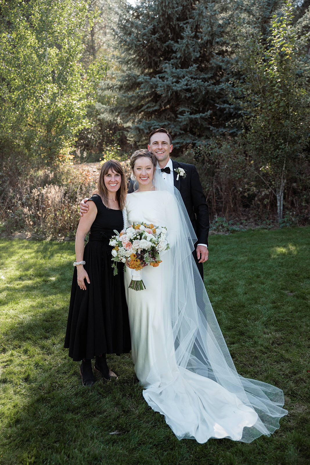 A bride and groom pose with their wedding coordinator Alex of Perfect Thirds & Co.