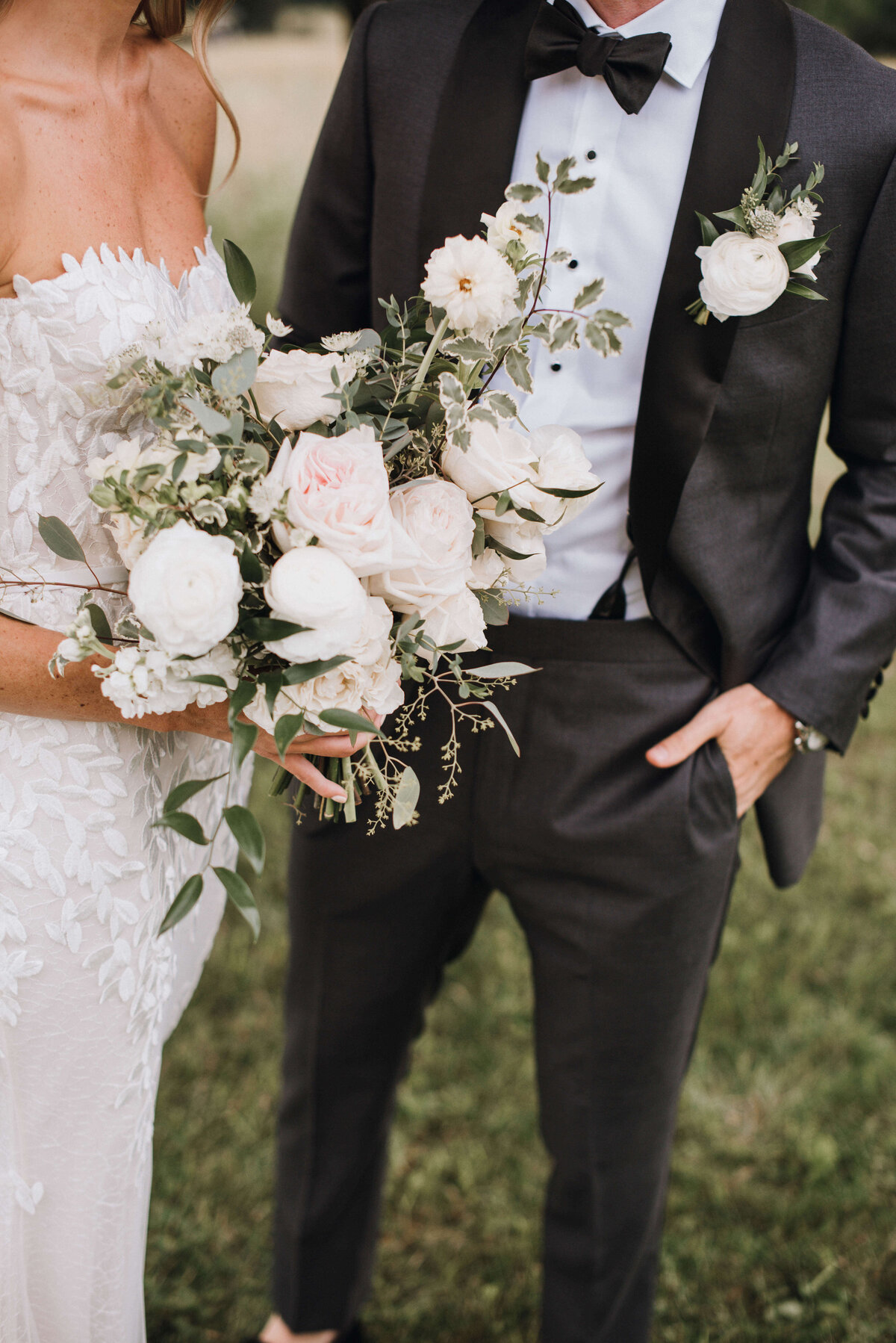 Detail of a bride and groom with white, green and blush wedding flowers