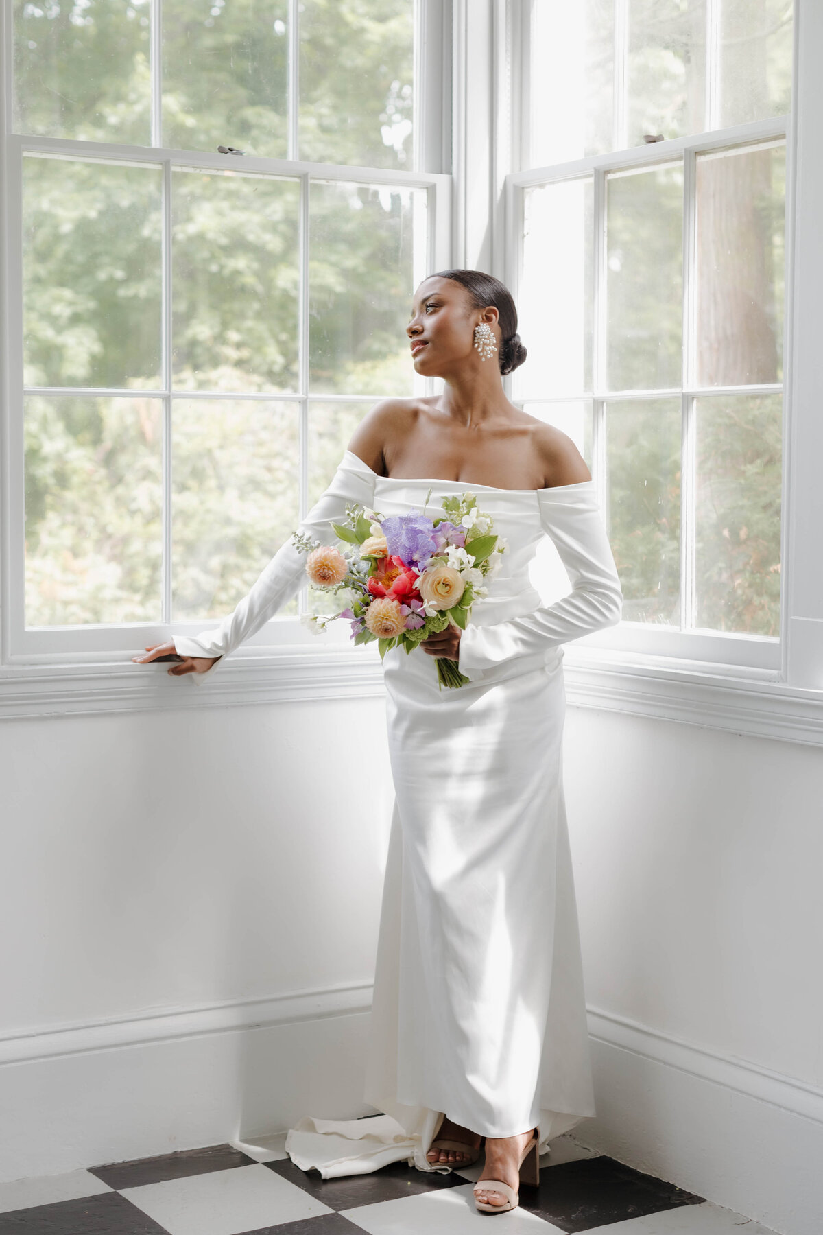 Luxury bridal portrait featuring an elegant bride holding vibrant florals, captured with refined sophistication by a documentary wedding photographer.