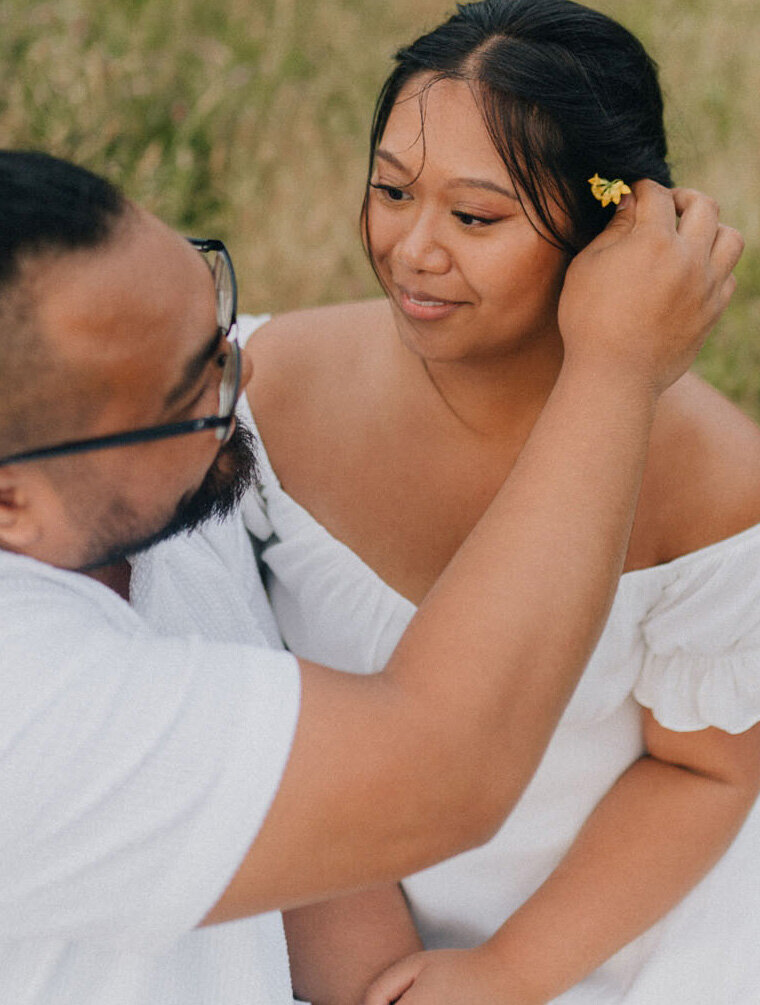 Guy puts flower into girl's hair