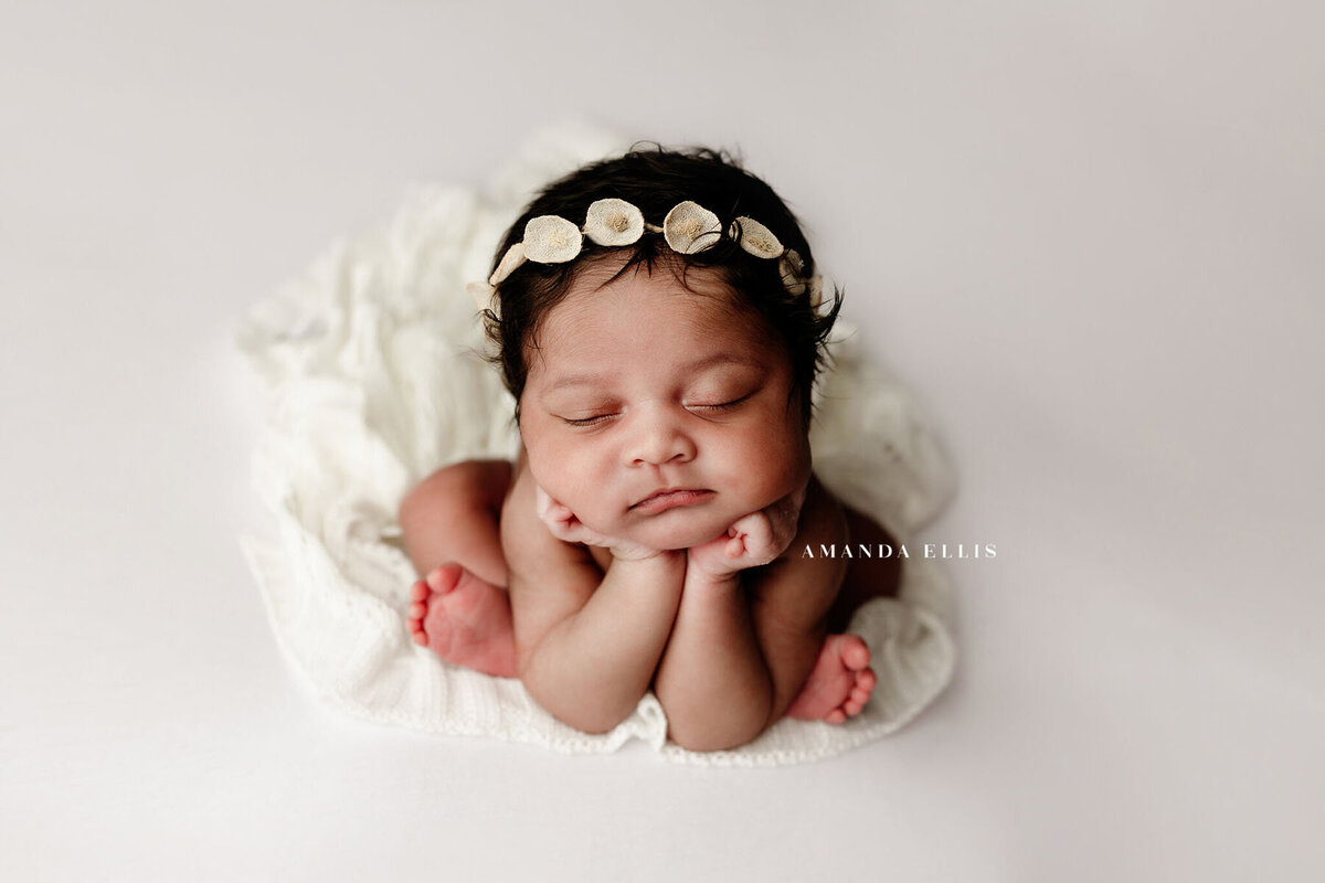 Brightly lit close up portrait of baby with flower crown