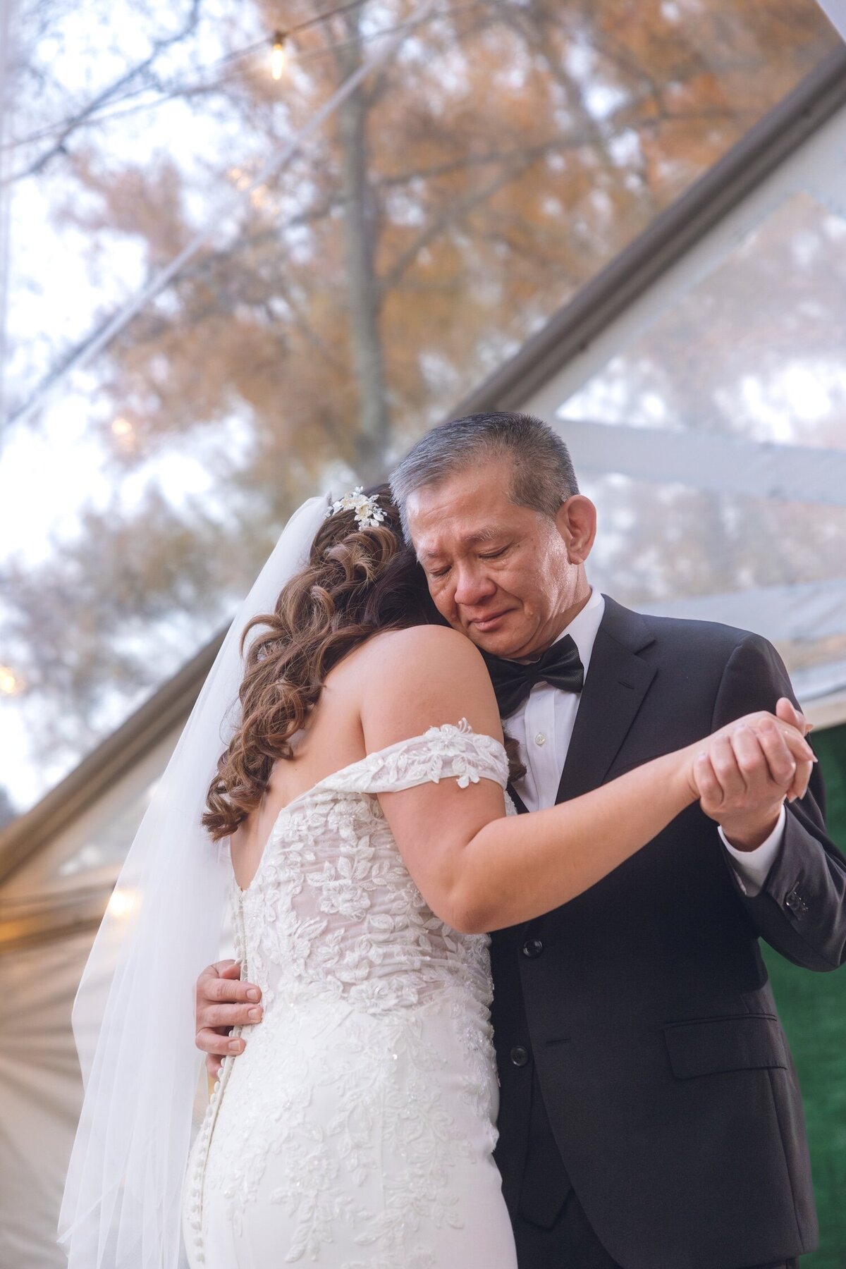 Bride hugging her dad during a sweet father-daughter dance moment.