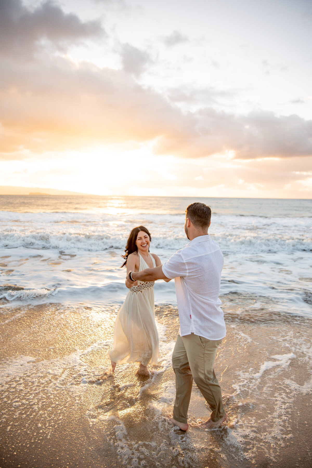 Maui Couples Photographer captures man and woman dancing in water during beach engagement photos
