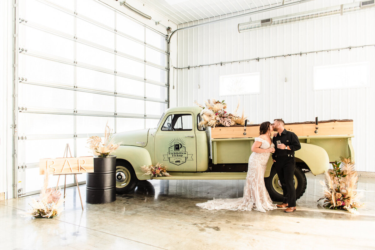 Bride and groom in front of vintage green truck at 52 North Venue, an industrial and unique wedding venue in Sylvan Lake, AB, featured on the Brontë Bride Vendor Guide.52 North Venue, an industrial and unique wedding venue in Sylvan Lake, AB, featured on the Brontë Bride Vendor Guide.