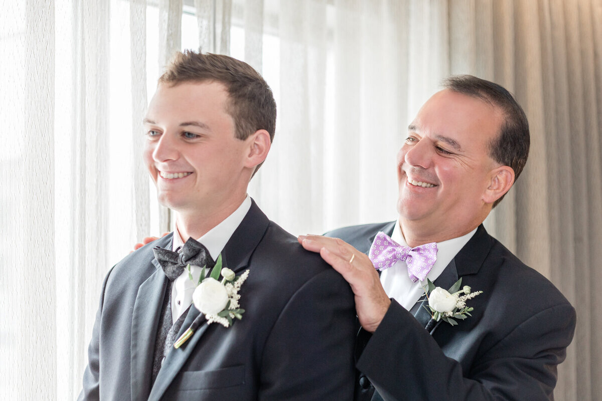 Father of the groom helps son get ready for his luxurious wedding