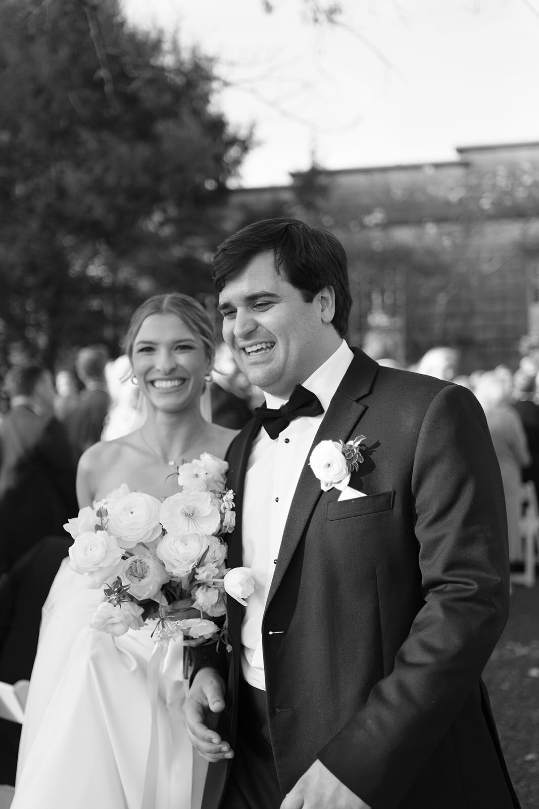Black and white photo of the bride and groom smiling and walking back up the aisle after their wedding ceremony at Burritt on the Mountain in Huntsville, Alabama, photographed by Perry Hancock.
