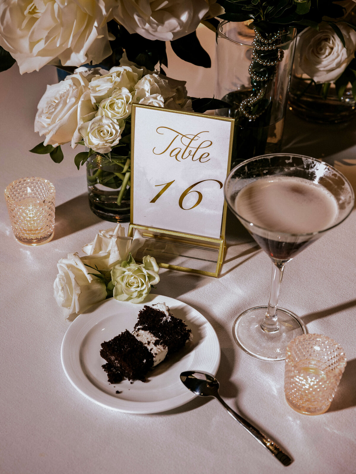 night-flatlay-with-direct-flash-showing-espresso-martini-chocolate-cake-and-white-bouquet-on-reception-table