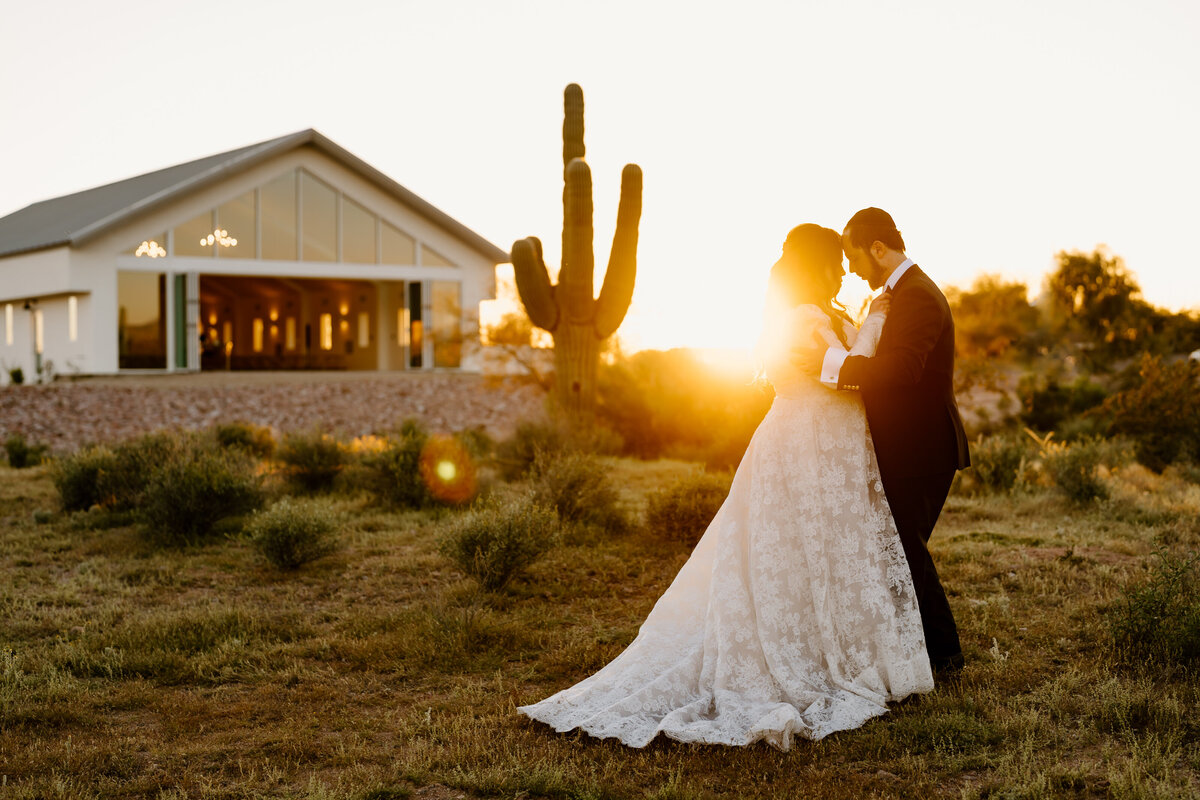 bride and groom with foreheads together during sunset in the desert