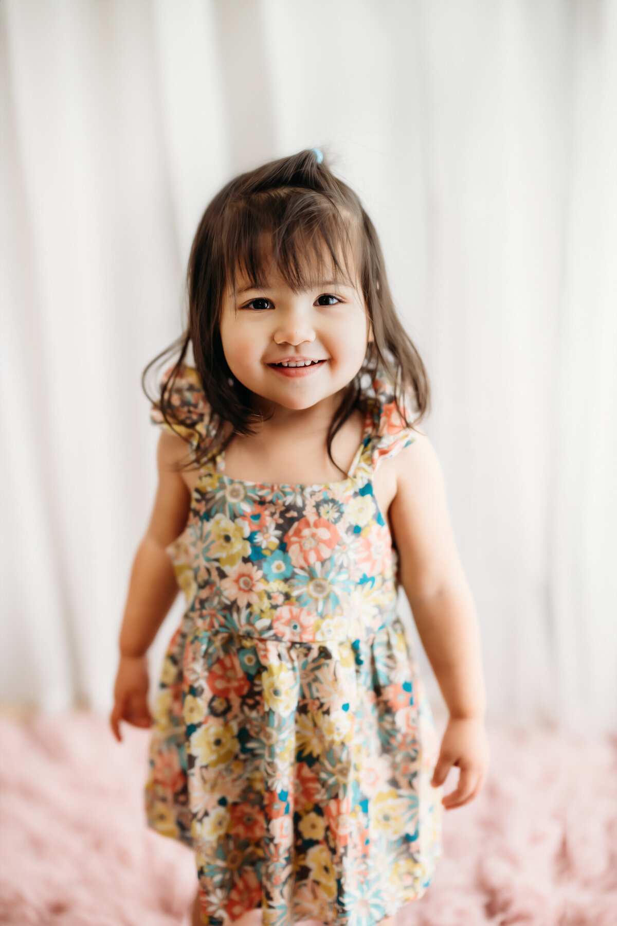 little girl smiling at the camera during her studio sesion