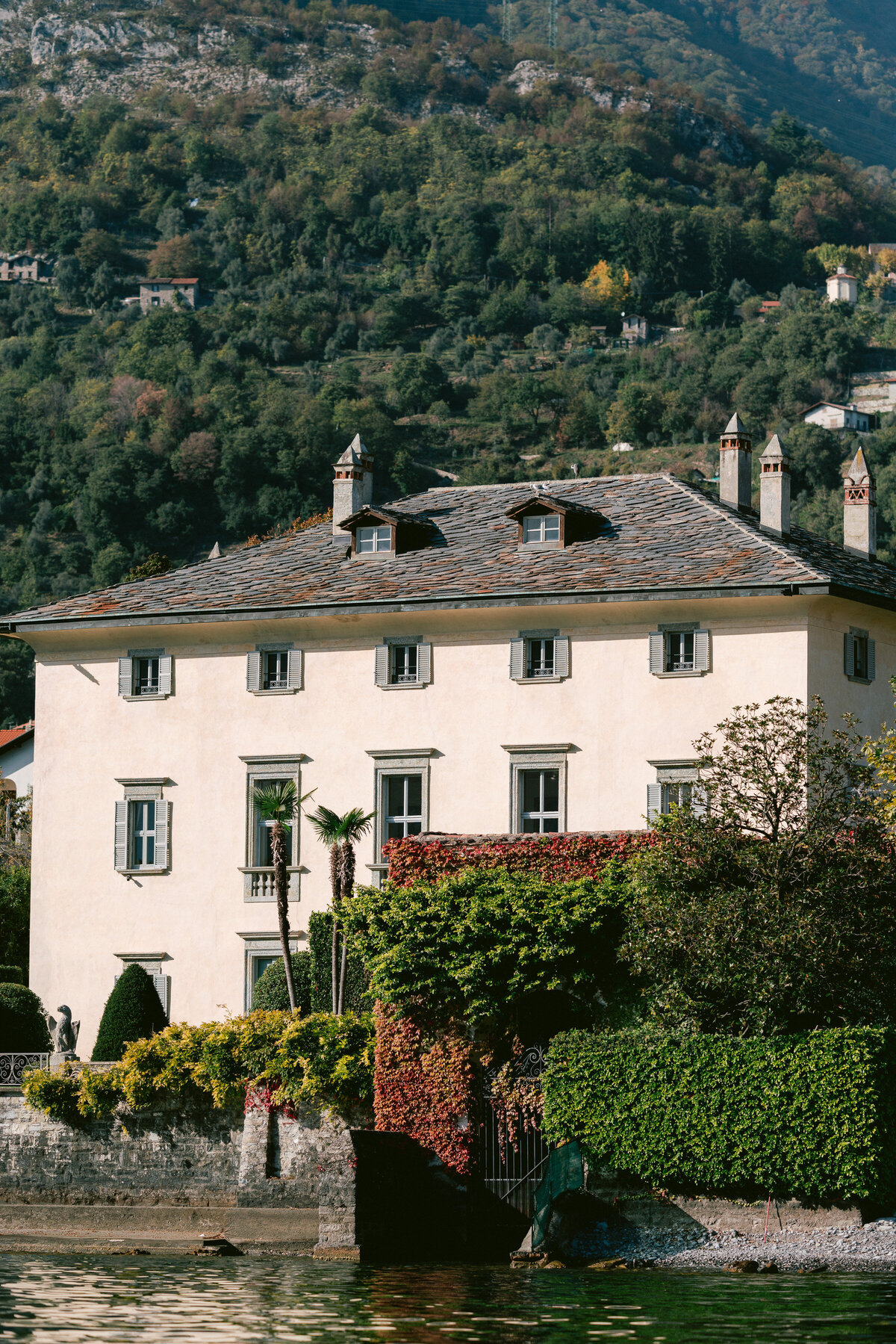 White building with green shutters overlooking Lake Como, Italy