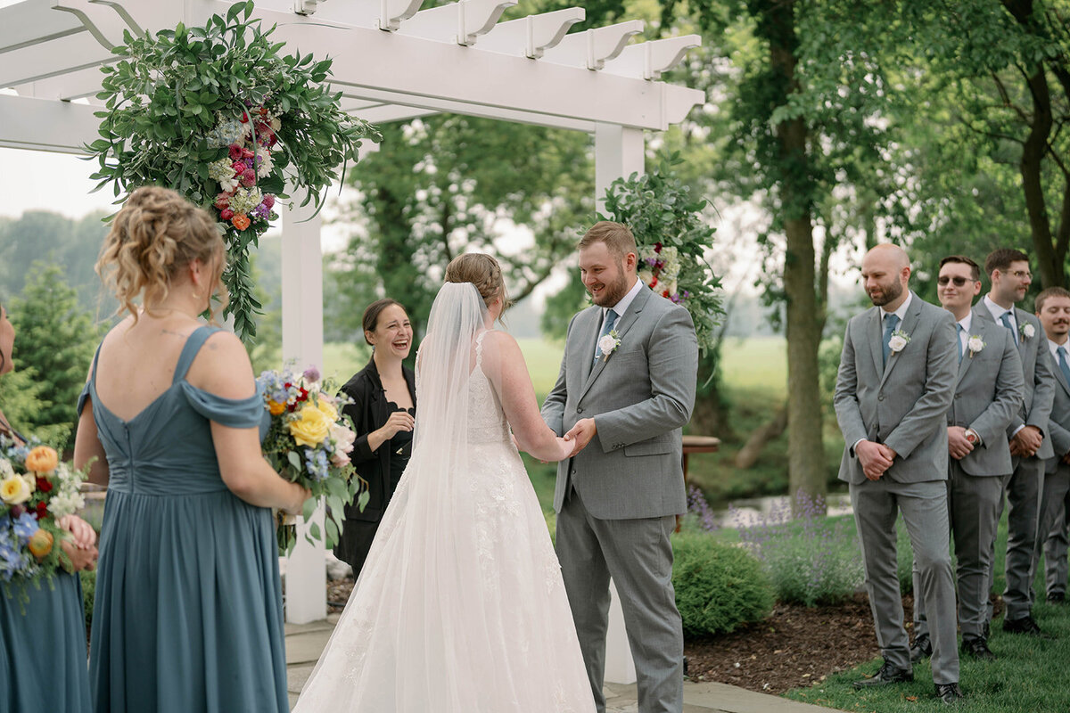 Candid side-angle view of the couple during their wedding ceremony at The Blue Heron Barn.