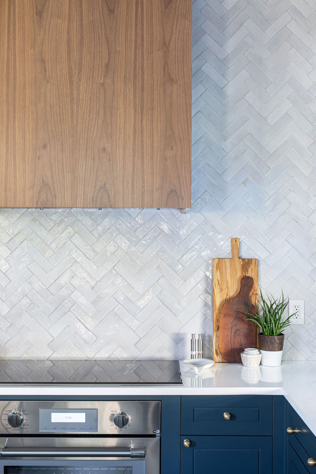 hello-home-austin-contemporary-navy-kitchen-remodel-wood-vent-hood-zelliege-herringbone-backsplash-open-layout-4