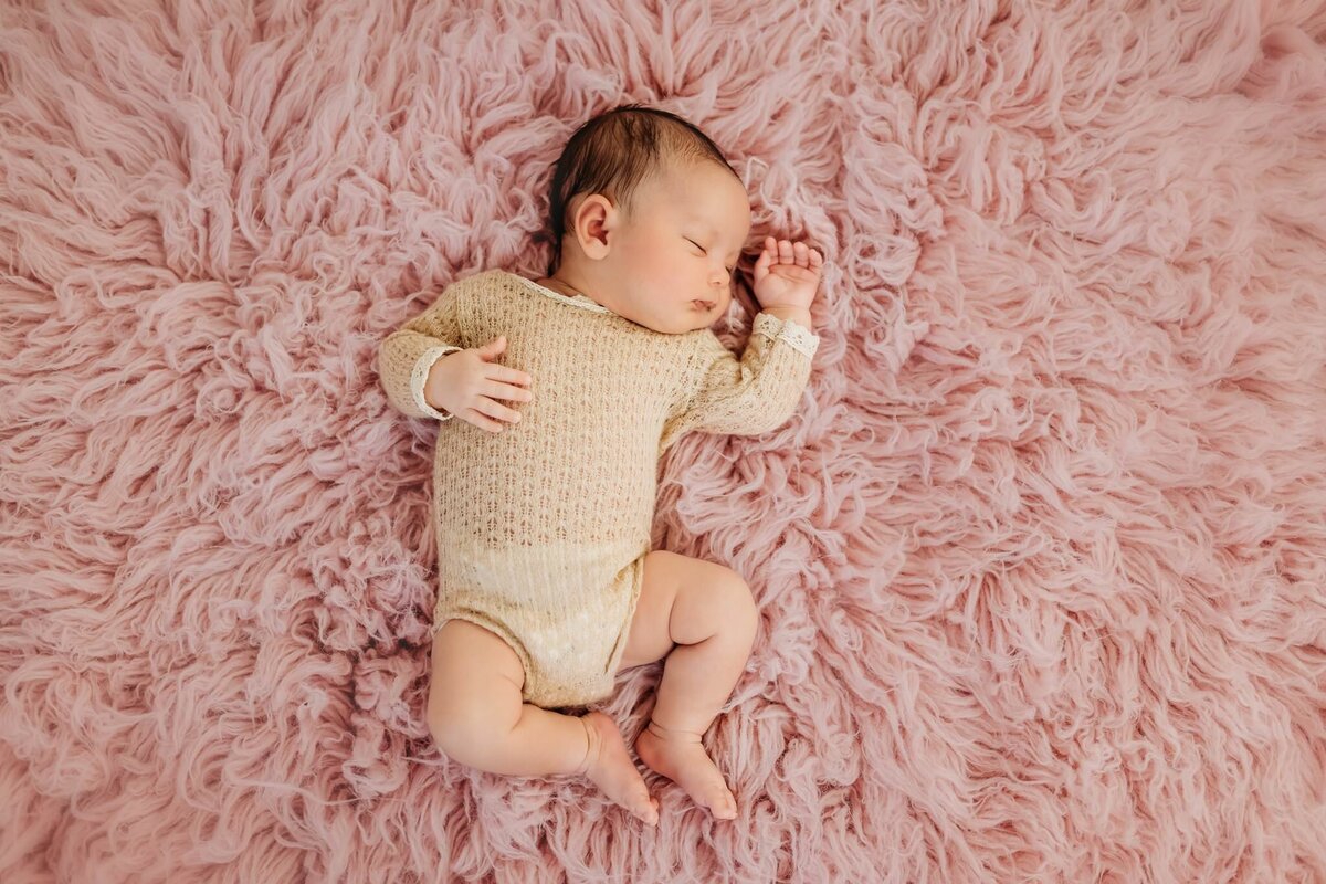 newborn-sleeping-pink-rug