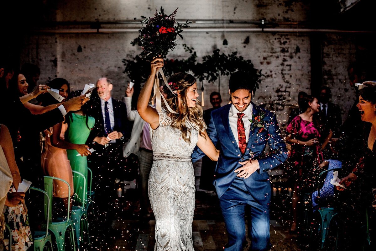 A couple exits their ceremony at a Joinery wedding.