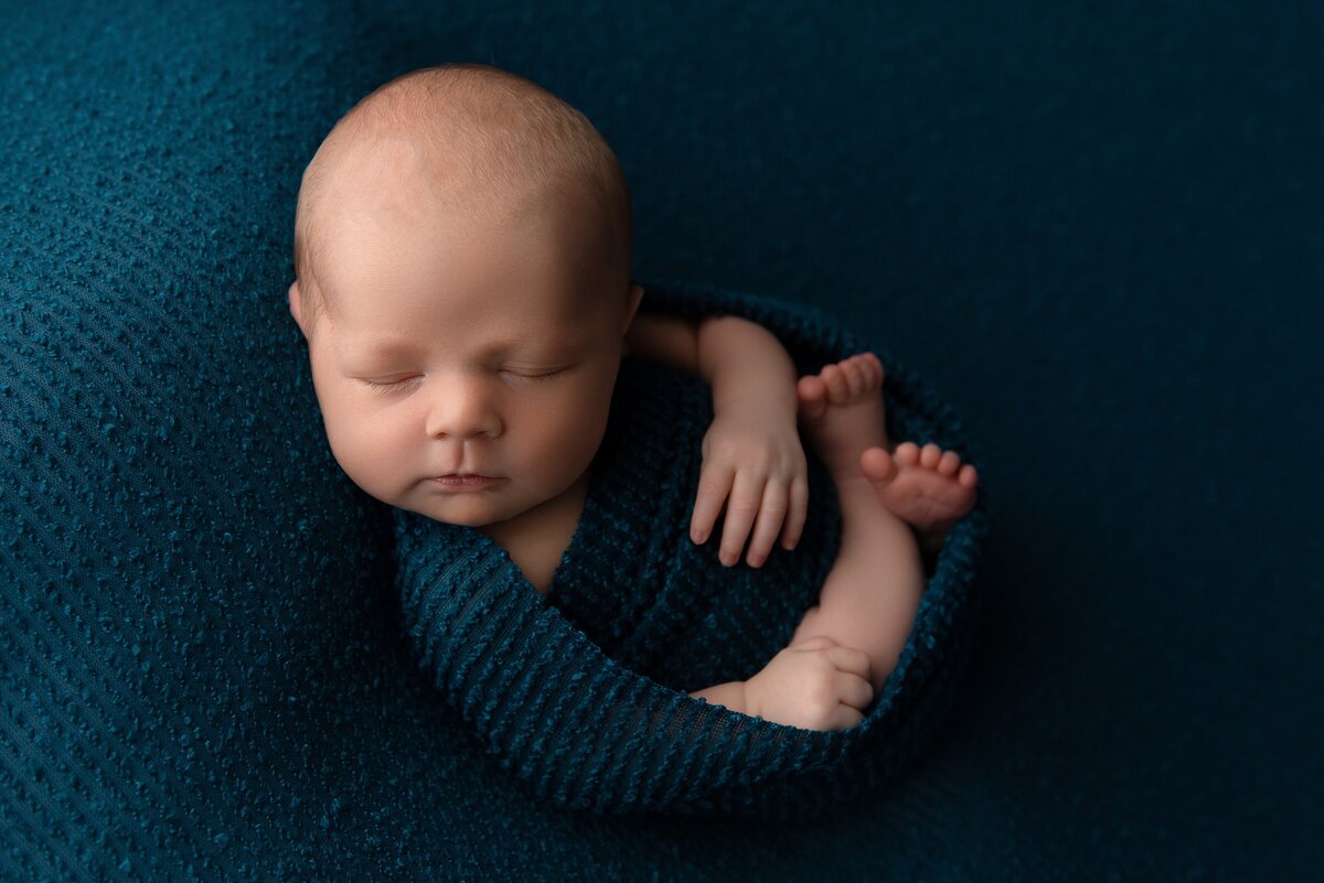 newborn baby on teal blanket