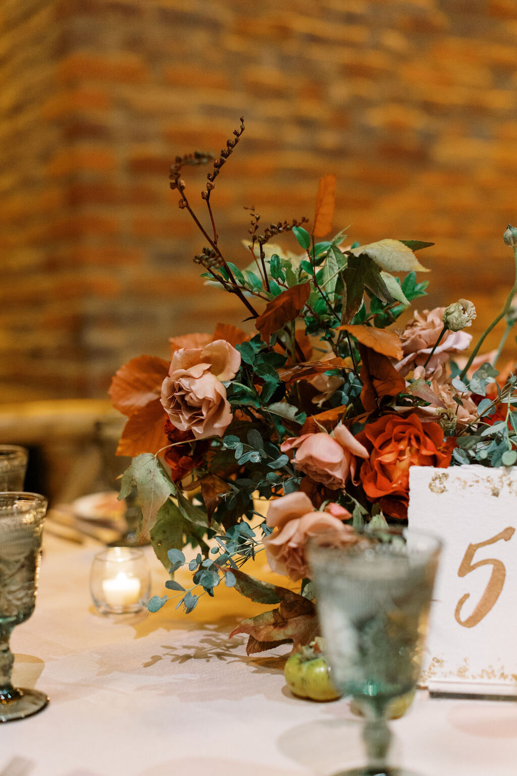 Lush floral centerpiece with autumnal tone flowers and textural elements including garden roses, fruiting branches, ranunculus, dahlias and fall foliage. Nashville wedding florist at Clementine Hall.