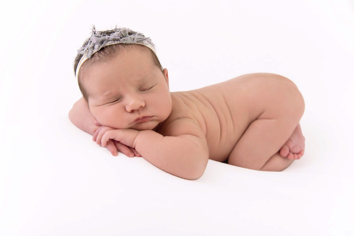 newborn girl on a white background for her newborn photography session Burlington