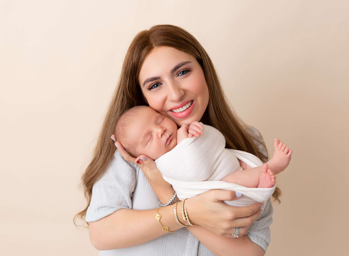 Mom holding her newborn baby boy during baby photoshoot in Brooklyn, New York